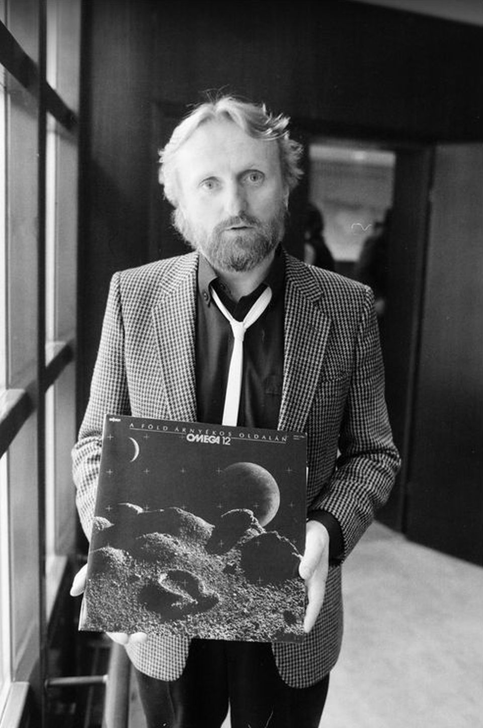 Benkő László 1986-ban kezében az Omega 12., A Föld árnyékos oldalán című albumával, amin a Fekete pillangó című dal is hallható